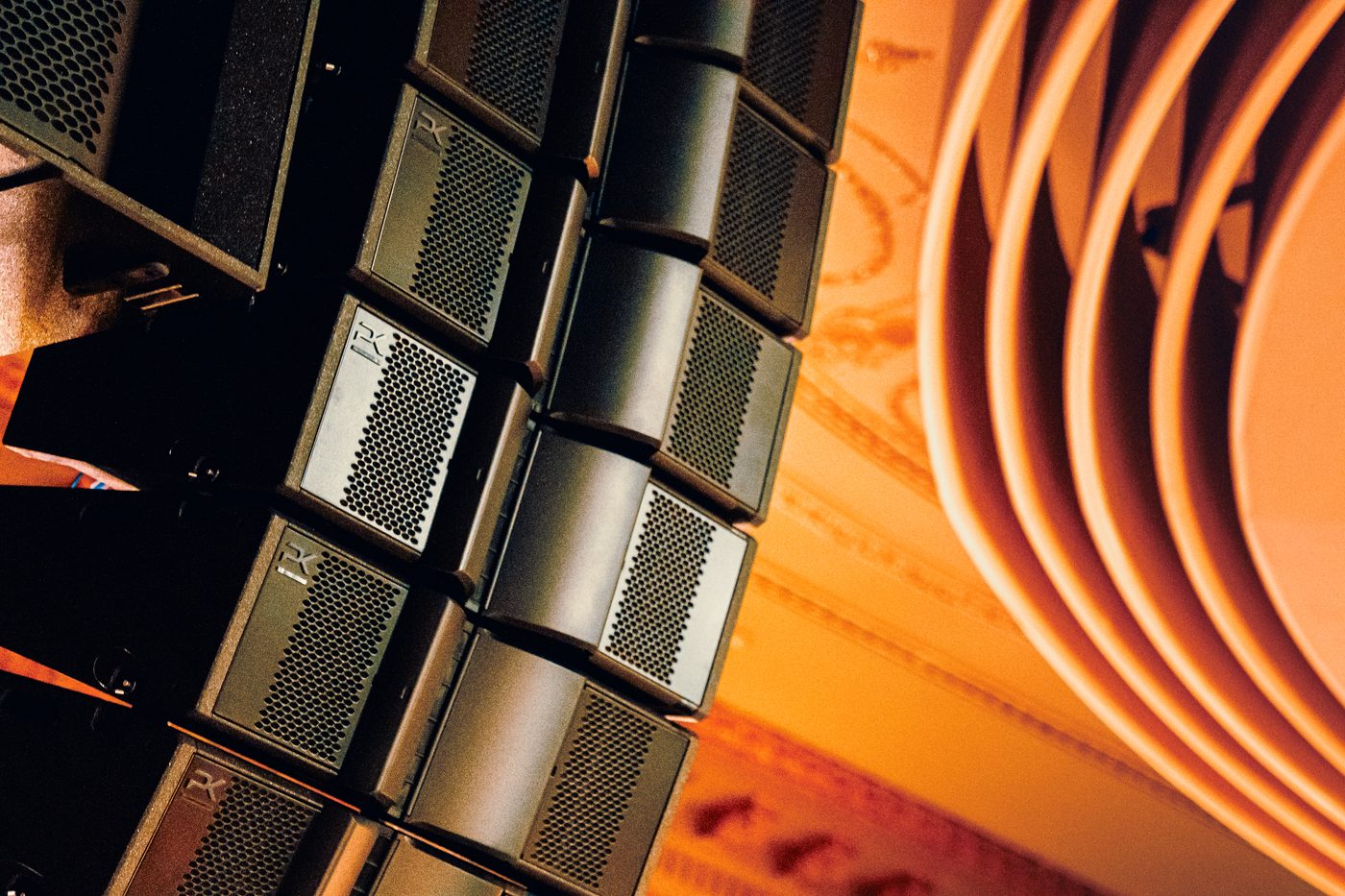 PK Sound robotic line array modules under warm stage lighting
