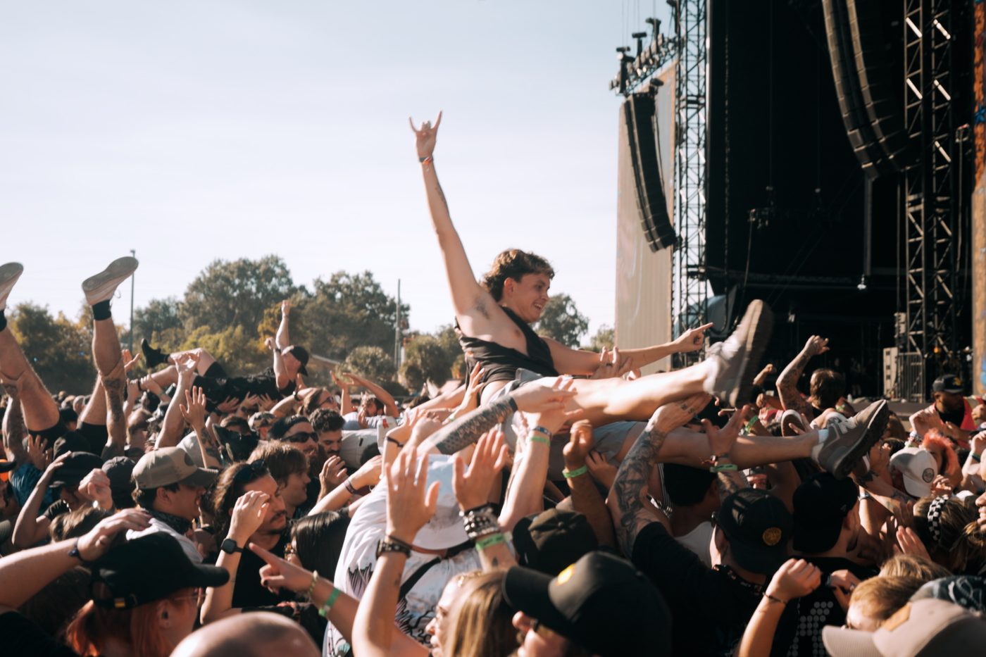 Festival audience with hands raised in front of the stage